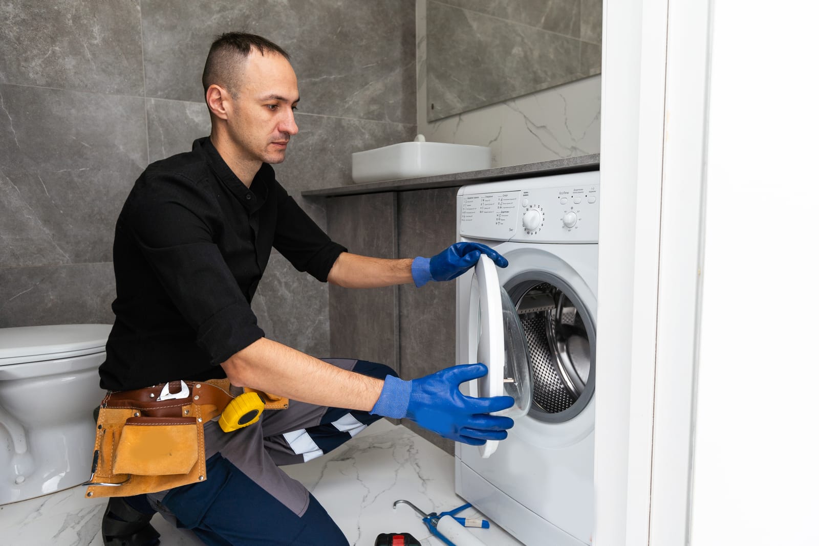 Professional Washing Machine Repair Assessment - Appliance Repair Men - Appliance Repair Men A professional engineer inspecting a washing machine to diagnose common mechanical and electrical faults in a home kitchen.