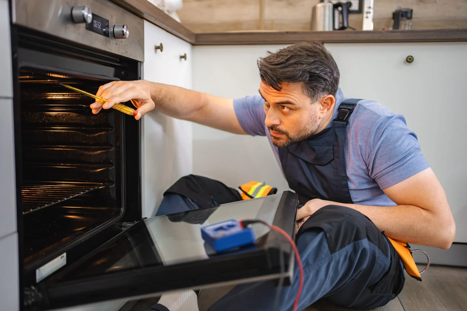 98412914_mid-adult-technician-repairing-kitchen-oven - Appliance Repair Men - Appliance Repair Men Repairs in Hightown