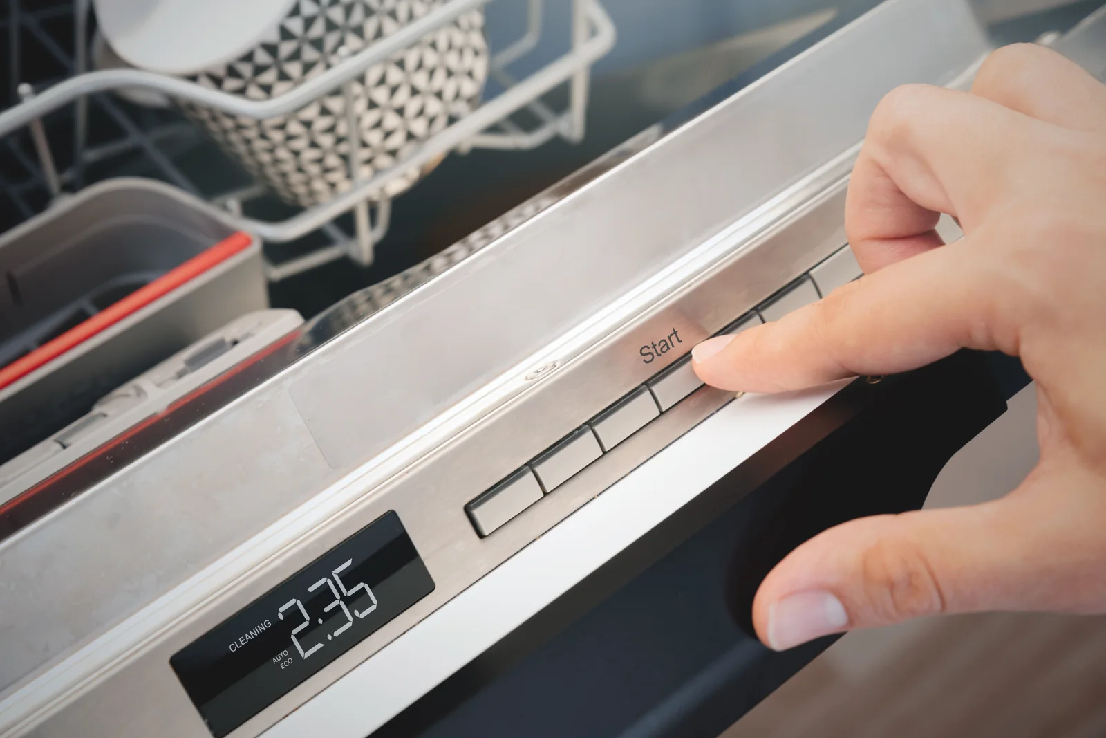 Dishwasher Not Starting When the Lights Come On but Nothing Happens - Appliance Repair Men - Appliance Repair Men Engineer checking the door latch on an integrated dishwasher not starting in a UK kitchen with the plinth removed