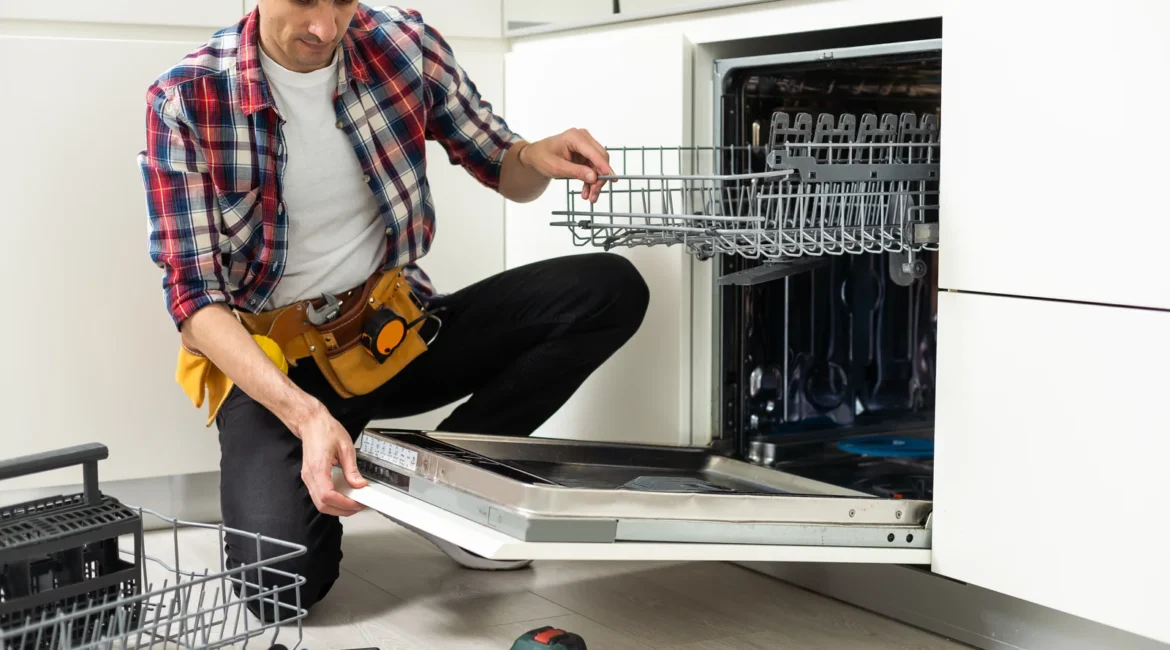 Engineer removing the filter from a noisy dishwasher to check the drain pump in a Crosby kitchen with integrated units
