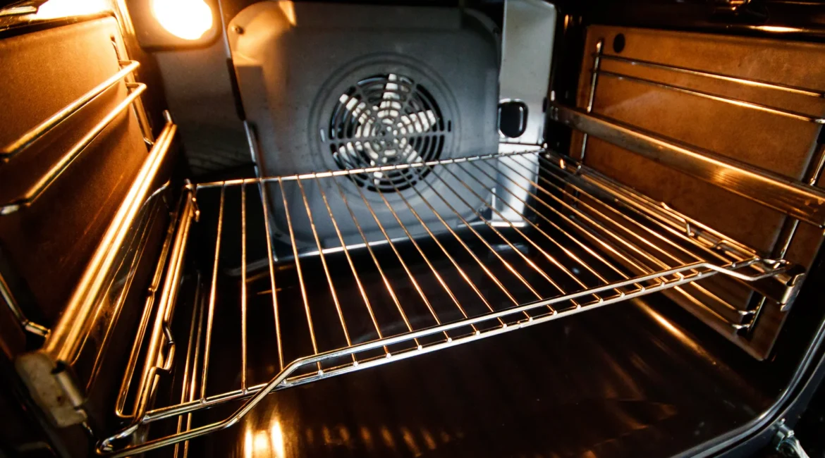 Engineer looking through the glass door at an oven fan not working inside a built-in electric oven in a Crosby kitchen